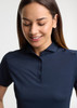 A navy women's short sleeve polo shirt with a collar and button placket, featuring a branding logo.