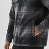 A plaid jacket featuring a grey and black pattern, with a sherpa lining and front pockets. It has a logo.