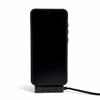 A black smartphone set on a stand with a charging cable connected, featuring a logo on the cable.