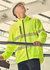 A bright yellow rain jacket with reflective stripes, worn by a person in a safety helmet, standing indoors.