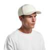 A white perforated cap displayed on a model, featuring a solid front panel and a logo on the side.