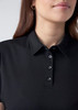 A women's short sleeve polo in black with a collar and button details, featuring a subtle logo.