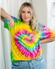 A tie-dye adult T-shirt in vibrant yellow, pink, green, and blue patterns, featuring a heart design.