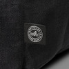 A black backpack made from recycled ocean plastic with a small logo patch.