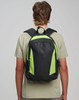 A black and green backpack with a logo, worn on the back of a person, featuring two shoulder straps.