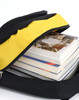 A black and yellow backpack unzipped with several stacked books visible inside. The backpack features a logo.