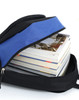 A black and blue backpack with a zippered opening, filled with several stacked books.