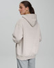 A unisex premium fleece oversized hoodie in a light beige colour, featuring a hood and a relaxed fit.