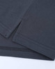 A close-up of a dark grey cotton/poly pique polo shirt, featuring seams and a small side split.