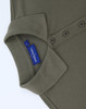 An olive green cotton/poly pique short-sleeve polo shirt with a collar and buttons, featuring a branding label.