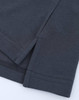 A close-up of a grey cotton/poly pique polo shirt showcasing the stitching and hem details. The shirt has a logo.