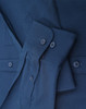 A navy blue long-sleeve cotton blend shirt with buttons and a folded sleeve detail. It features a logo.