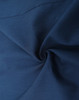 A close-up of a dark navy cotton blend fabric, showcasing smooth texture and softness. Features a logo in the corner.
