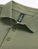 A men's ultrafine cotton pique polo in olive green with a collar and buttons, featuring a branding label.