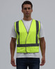 A bright yellow safety vest featuring reflective strips, worn by a model against a plain background.