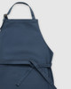 A navy blue apron with adjustable straps and a tie belt, featuring a simple, clean design.