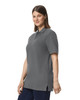 A grey Gildan Hammer Adult Double Pique Polo shirt on a female model, featuring a collared neck and short sleeves.