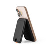 A smartphone in a black Cozy Phone Wallet, showcasing a sleek design with a stand feature.