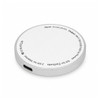 A round, silver wireless charger with a smooth surface and a USB-C input on the side. It has a discreet logo.