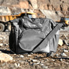A grey cooler bag with a shoulder strap and multiple compartments, featuring a logo on the front.