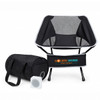 A portable black camping chair with a mesh back, accompanied by a black storage bag and a small speaker.