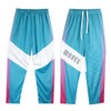 Custom youth active pants in teal with purple and white geometric designs, featuring a logo on one side.