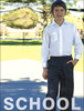 A young boy in a white shirt and dark grey trousers stands outdoors. The trousers have an elastic waistband and a logo.