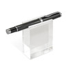 A black pen displayed on a clear acrylic stand, showcasing its sleek design. The stand is simple and modern.