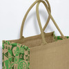 A jute tote bag in natural brown with a vibrant green patterned design and two sturdy handles.