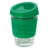 A drink cup featuring a clear glass body and a green silicone lid and sleeve, including a logo.