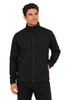 A soft shell jacket in black, featuring a high collar and full zip, modelled by a man. Includes a logo.