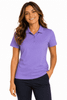 A woman wearing a purple polo shirt, smiling and standing confidently with her hands in her pockets.