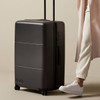 A large black suitcase on wheels with a retractable handle and a logo.