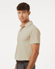 A men's polo shirt in a light beige colour, featuring a classic collar and short sleeves. It has a logo on it.
