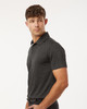 A grey men's polo shirt with a collar, featuring short sleeves and a logo on the chest.