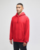 A red pullover hooded sweatshirt with a front pocket and logo on the sleeve, displayed on a model.