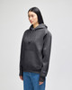 A grey hooded sweatshirt with a front pocket, featuring a logo on the sleeve, modelled by a woman.