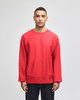 A red Champion Reverse Weave® adult crew sweatshirt displayed on a model. The sweatshirt features a logo tag.