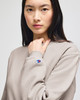 A cream-coloured crewneck sweatshirt with a logo on the sleeve, worn by a model.