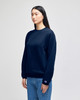 A navy blue crewneck sweatshirt with long sleeves, featuring a logo on one sleeve.