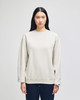 A cream-coloured adult crewneck sweatshirt with long sleeves and a logo on the sleeve.