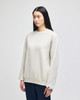 A light beige adult crewneck sweatshirt with a relaxed fit and a small logo.