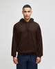 A brown pullover hooded sweatshirt with a front pocket and loose fit, featuring a logo on the chest area.