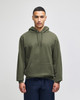 A green pullover hooded sweatshirt with a front pocket, worn by a model against a light background.