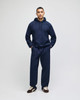 A navy pullover hooded sweatshirt paired with matching pants, featuring a logo on the sweatshirt.