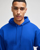 A blue pullover hooded sweatshirt with a front pocket and drawstring hood, worn by a model. It features a logo.