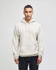 A light beige pullover hooded sweatshirt with a front pocket and a logo on the sleeve.