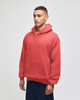 A red pullover hooded sweatshirt with a front pocket and a logo on the sleeve.