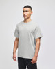 A grey Champion adult short-sleeve T-shirt displayed on a model. The shirt features a logo on one sleeve.