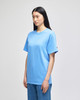 A light blue short-sleeve t-shirt displayed on a model, featuring a logo on the sleeve.
